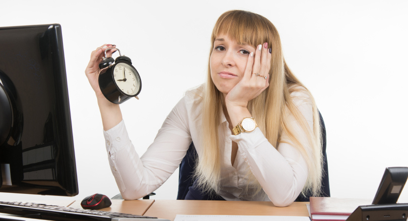 Sad women holding analogue clock